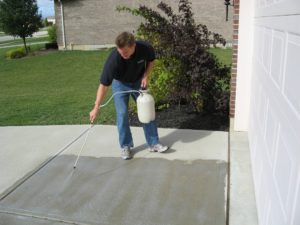 Person sealing concrete driveway