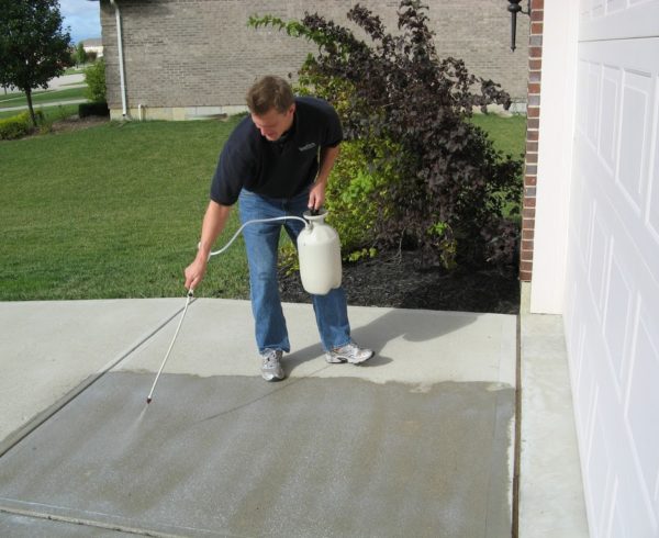 Person sealing concrete driveway